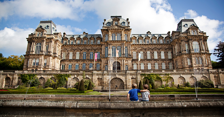 two little boys sitting looking at the exterior of The Bowes Museum